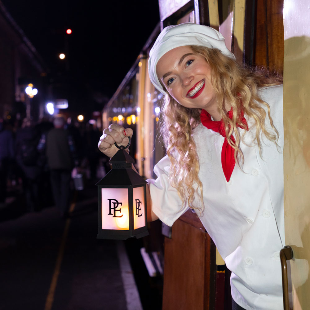 A chef on board The Polar Express Train Ride South Devon holding a lantern