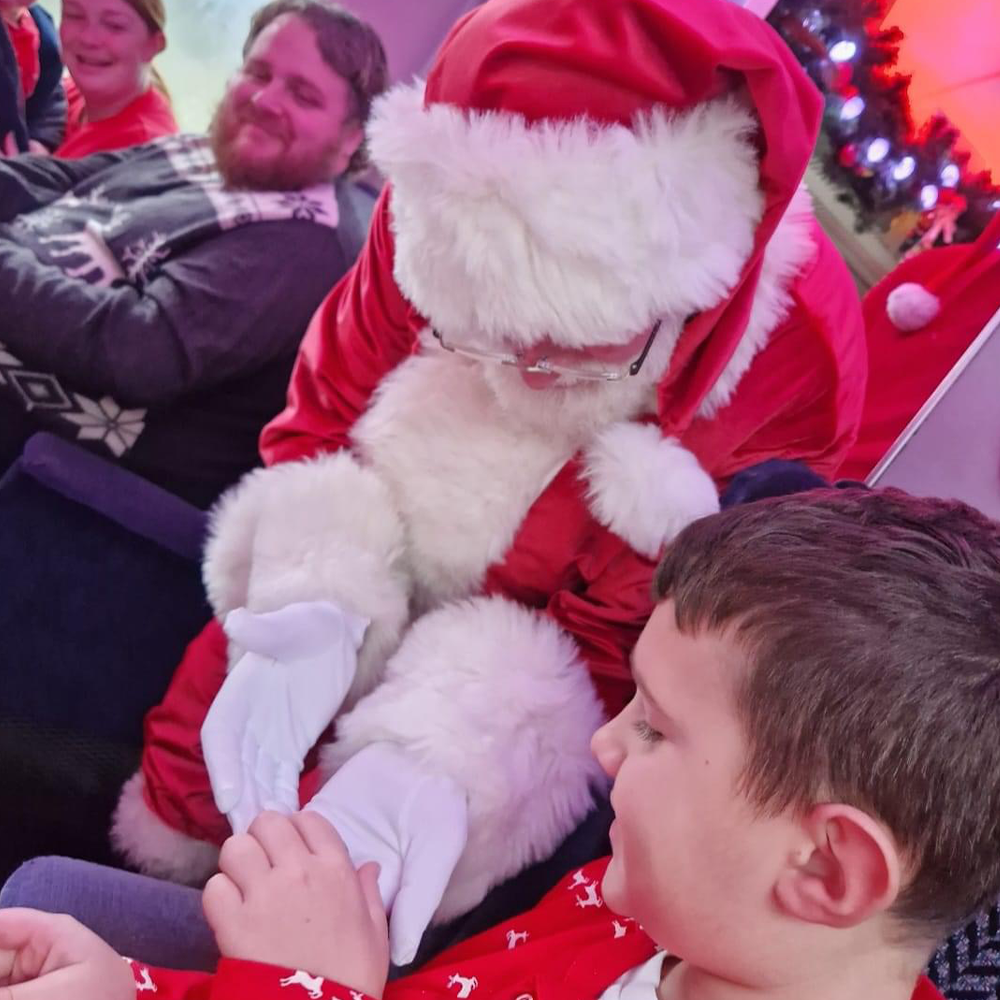 Santa gifting the first gift of Christmas on board The Polar Express Train Ride South Devon 