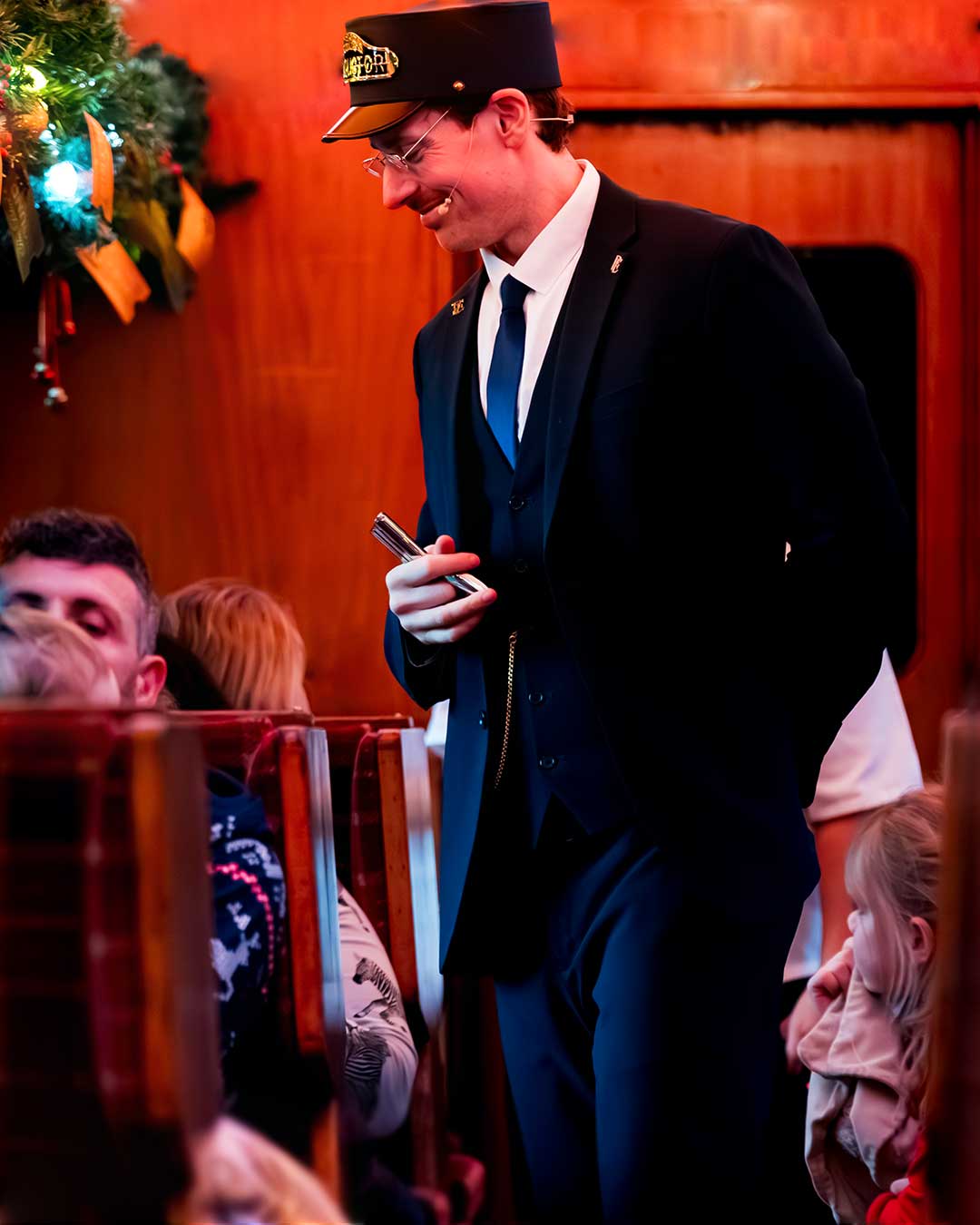 The conductor clipping tickets on THE POLAR EXPRESS™ Train Ride London